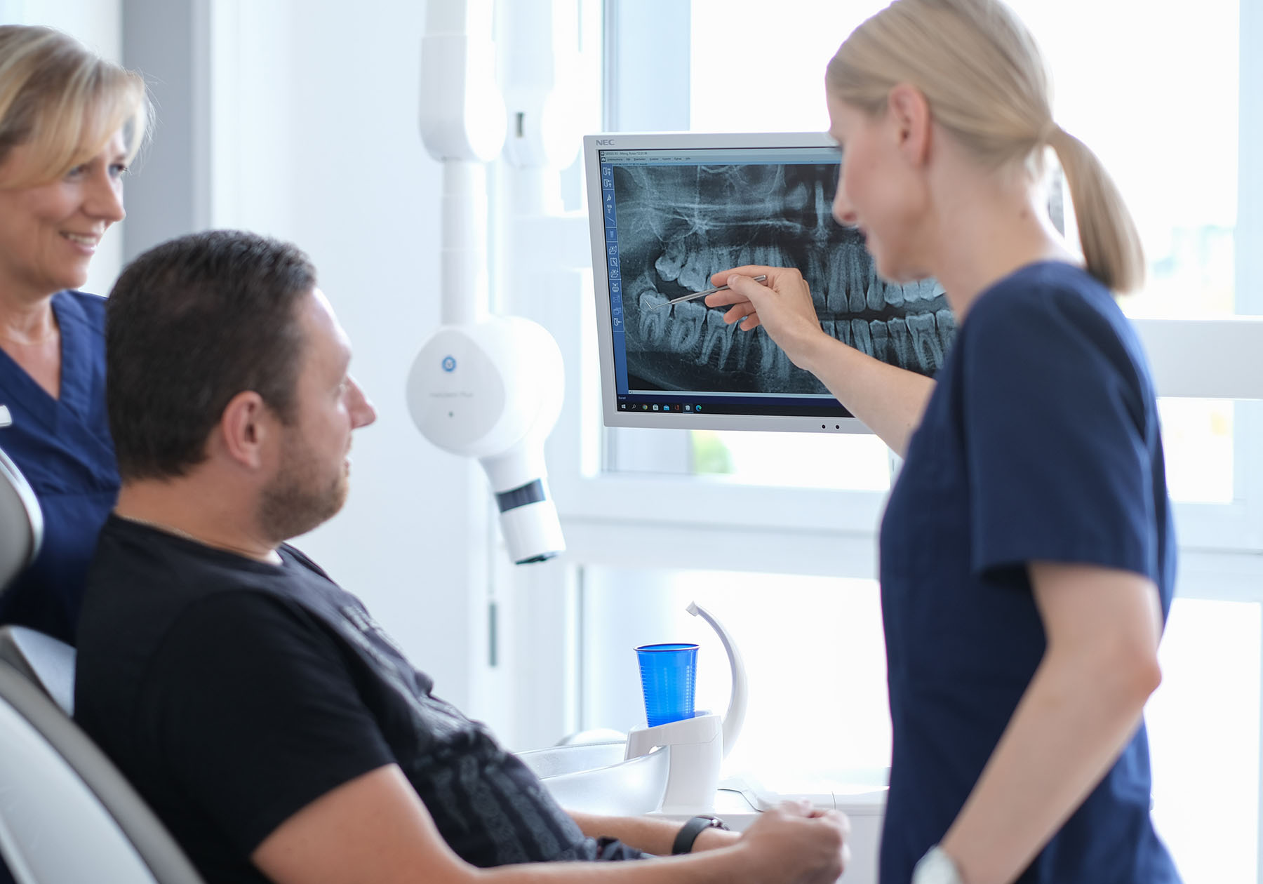 Zahnärztin erklärt Patient Röntgenbild